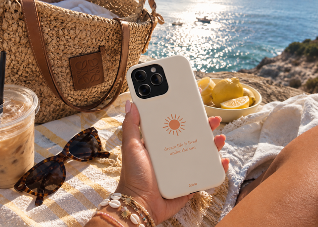 Cream Solova case held up at a seaside picnic